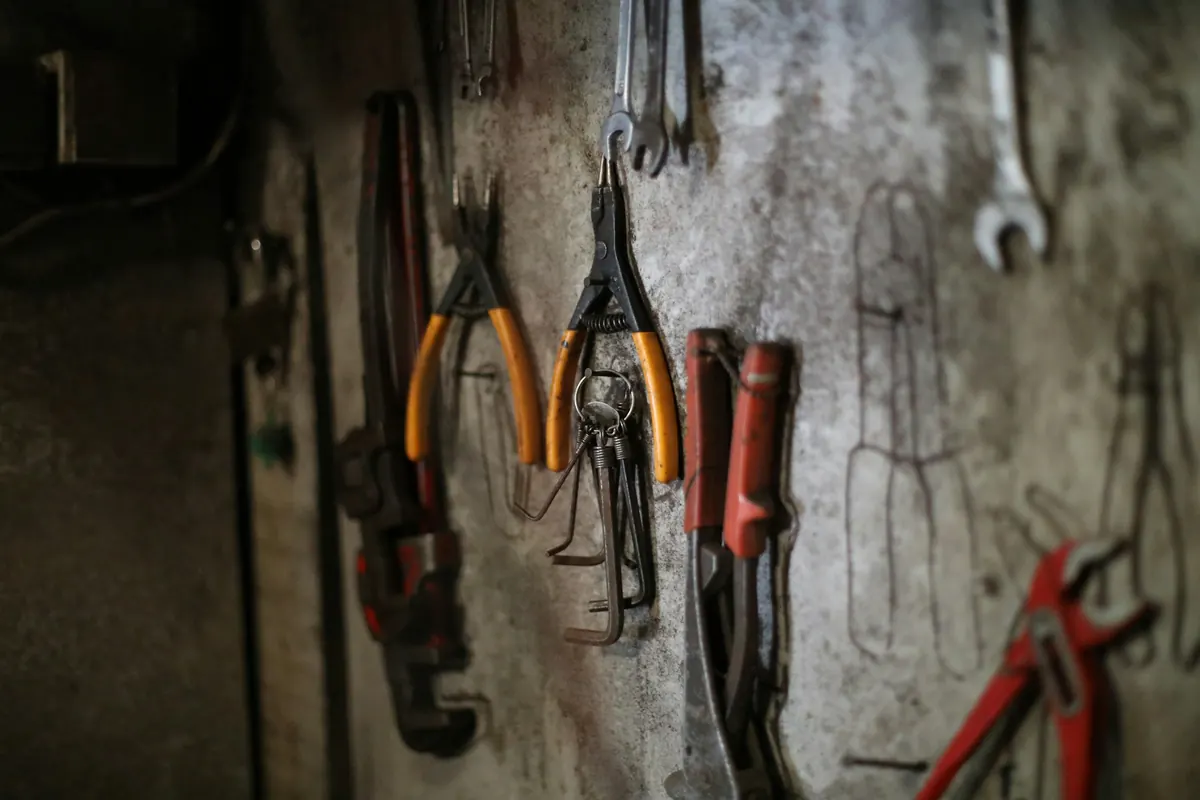 Herramientas de gasfitería colgadas en un muro de taller
