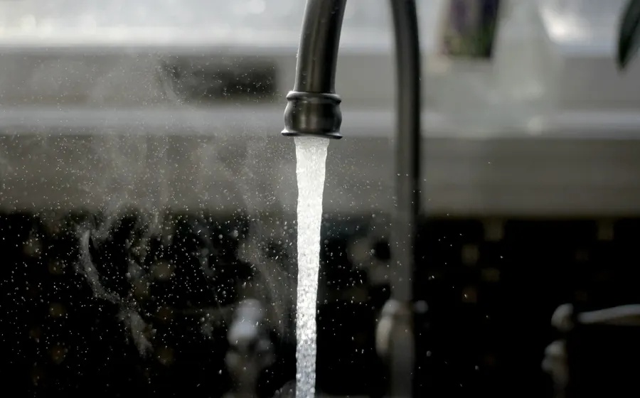 Agua corriendo desde una llave de cocina negra